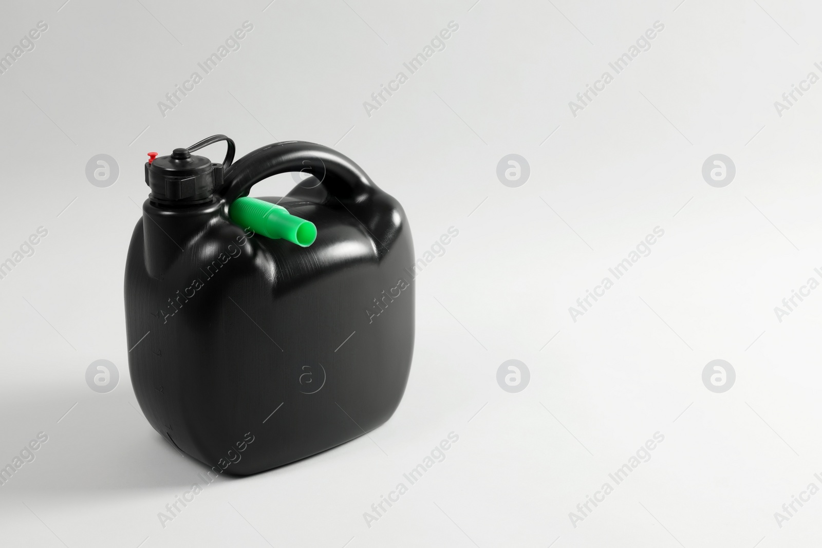 Photo of Black plastic canister with nozzle on light grey background. Space for text
