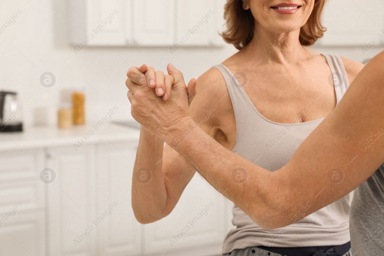 Photo of Happy senior couple dancing together at home, closeup