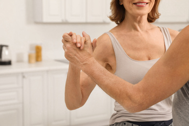 Photo of Happy senior couple dancing together at home, closeup