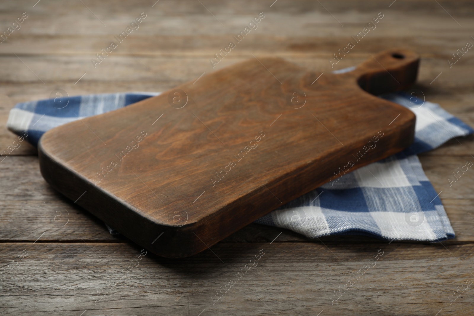 Photo of Board and kitchen towel on brown wooden table