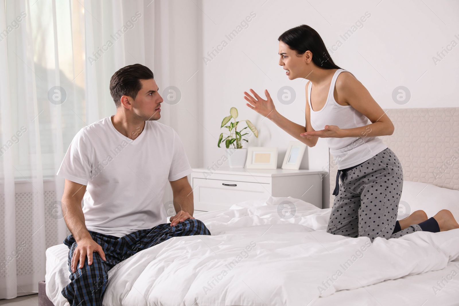 Photo of Couple with relationship problems quarreling in bedroom