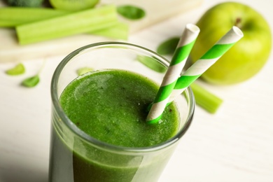 Delicious fresh green juice with straws in glass, closeup