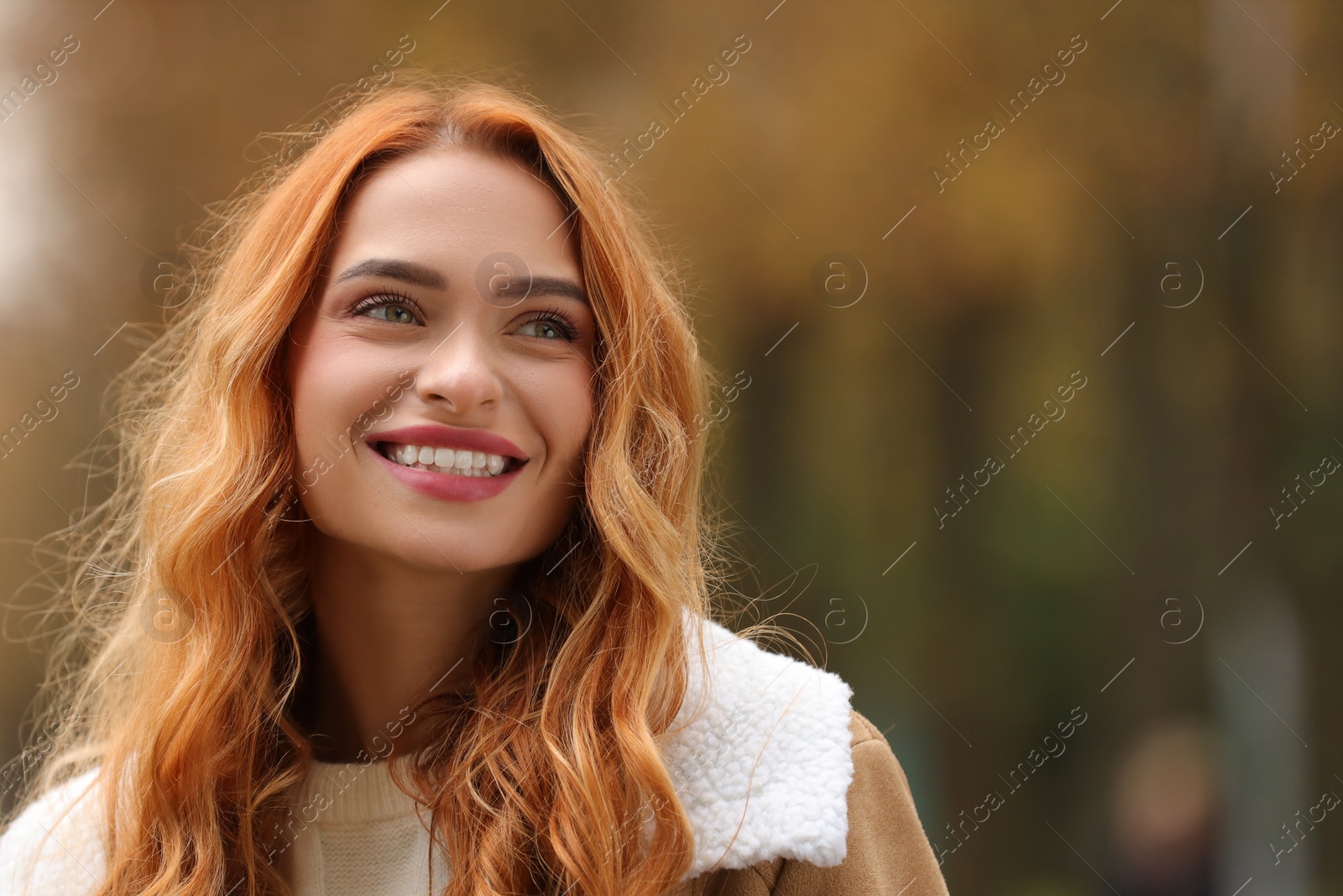 Photo of Autumn vibes. Portrait of smiling woman outdoors. Space for text