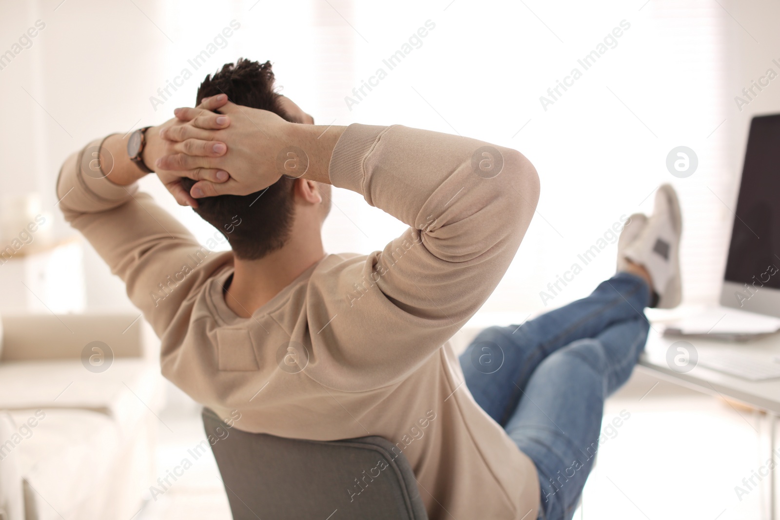 Photo of Young man relaxing at table in office during break