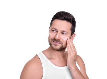 Photo of Man applying sun protection cream onto his face against white background