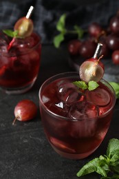 Photo of Delicious grape soda water on black table. Refreshing drink