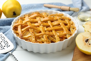 Photo of Tasty homemade quince pie on white wooden table, closeup