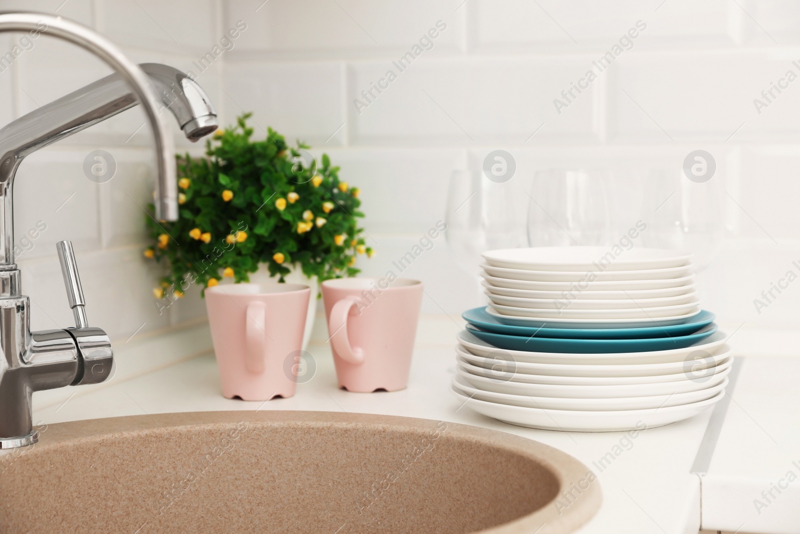 Photo of Clean dishes on counter near kitchen sink indoors