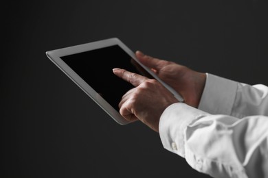 Closeup view of man using new tablet on black background