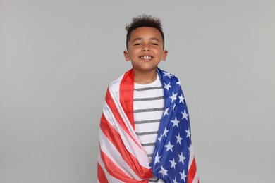 Photo of 4th of July - Independence Day of USA. Happy boy with American flag on light grey background