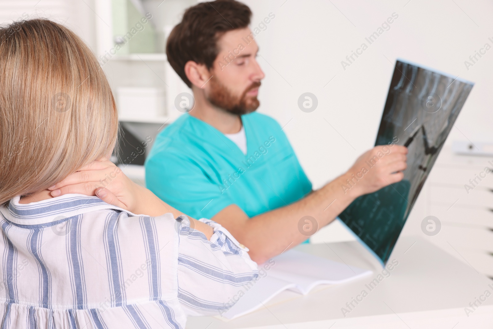 Photo of Doctor with neck MRI scan consulting patient in hospital