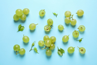 Photo of Flat lay composition with fresh ripe juicy grapes on light blue background