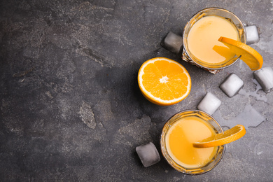 Fresh alcoholic Tequila Sunrise cocktails on grey table, flat lay. Space for text