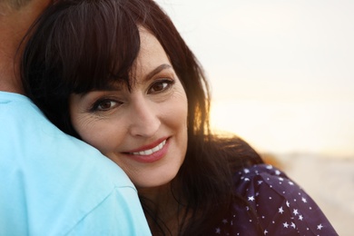 Photo of Happy mature couple spending time together on sea beach, closeup