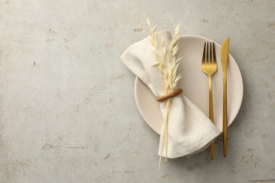 Photo of Stylish setting with cutlery, napkin, dry branch and plate on light table, top view. Space for text