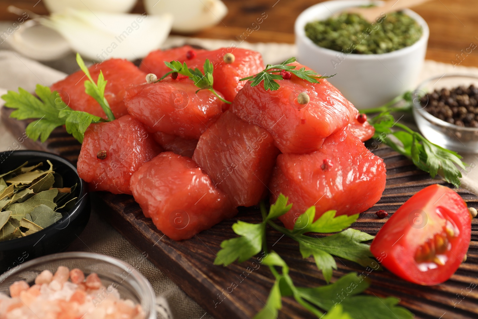 Photo of Raw beef meat and different ingredients for cooking delicious goulash on table, closeup