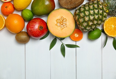 Photo of Set of fresh tropical fruits on white wooden background