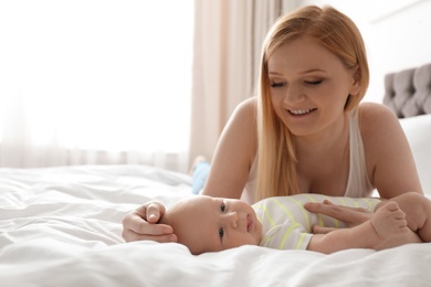 Photo of Mother with her little baby on bed at home