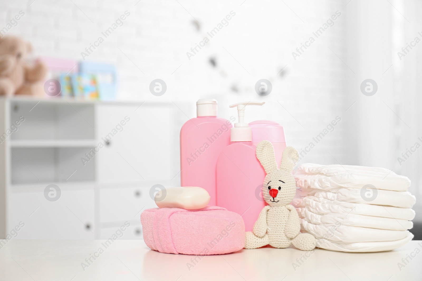 Photo of Baby accessories on table in nursery room. Space for text