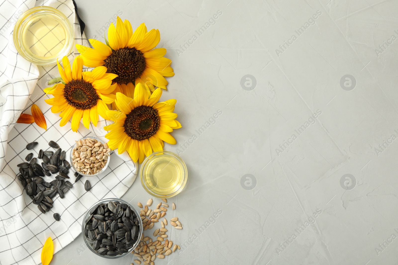 Photo of Flat lay composition with sunflower oil on grey table, space for text