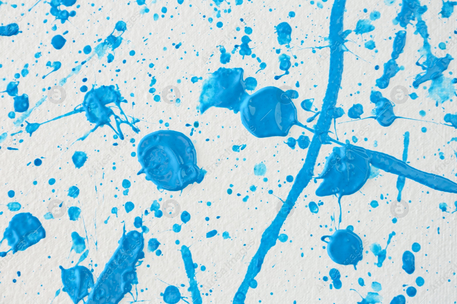 Photo of Blue paint splashes on white canvas as background. Art and creativity