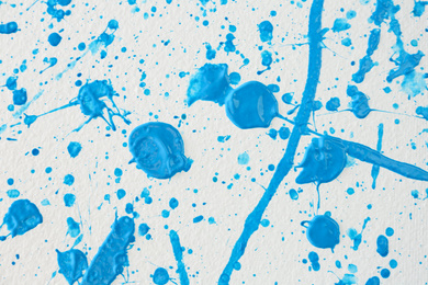 Blue paint splashes on white canvas as background. Art and creativity