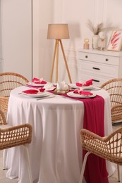 Photo of Color accent table setting. Plates, cutlery and pink napkins in dining room