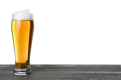 Glass of tasty beer on grey wooden table against white background