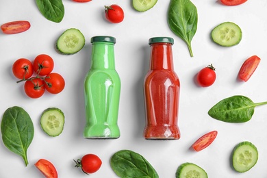 Flat lay composition with bottles of juices on white background