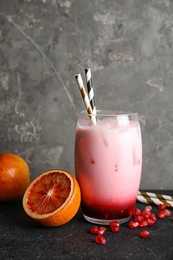 Photo of Glass of tropical cocktail with ice cubes and fruit on table. Space for text