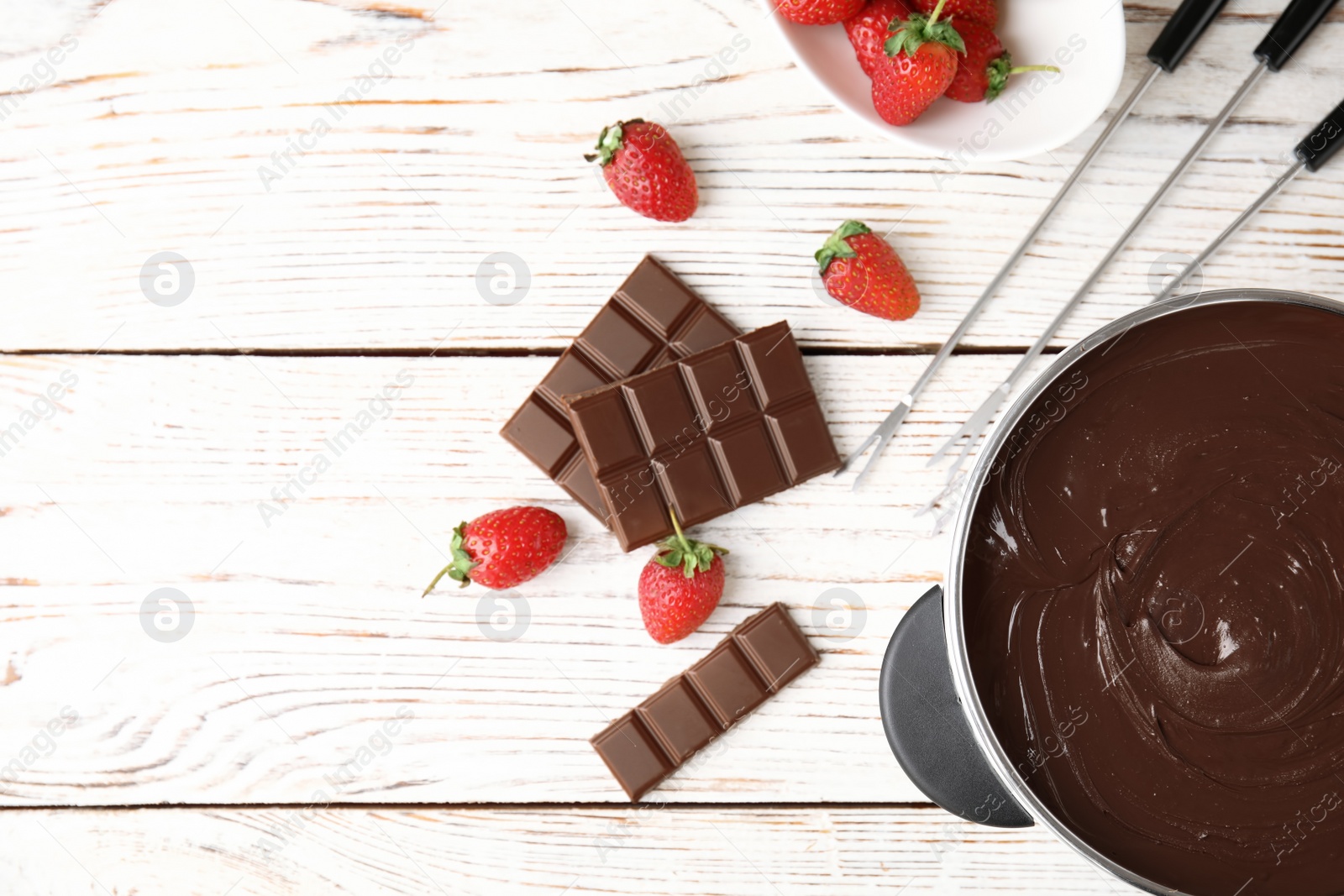 Photo of Flat lay composition with chocolate fondue in pot and space for text on wooden background