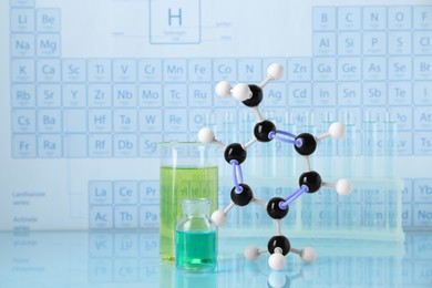 Molecular model and laboratory glassware on light surface