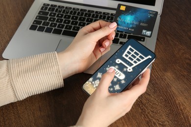 Image of Online shopping. Woman with credit card using smartphone for internet purchases at table, closeup