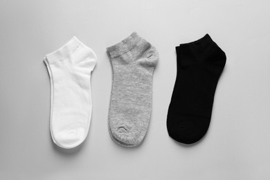Different pairs of socks on light grey background, flat lay