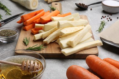 Photo of Composition with parsnips, carrots and other products on light grey table