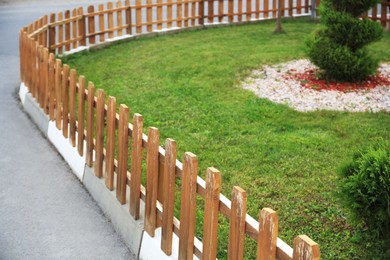 Photo of Small wooden fence near green grass outdoors