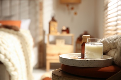 Photo of Burning candles on wooden chair in bedroom, space for text. Interior elements