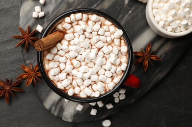 Tasty hot chocolate with marshmallows on dark textured table, flat lay