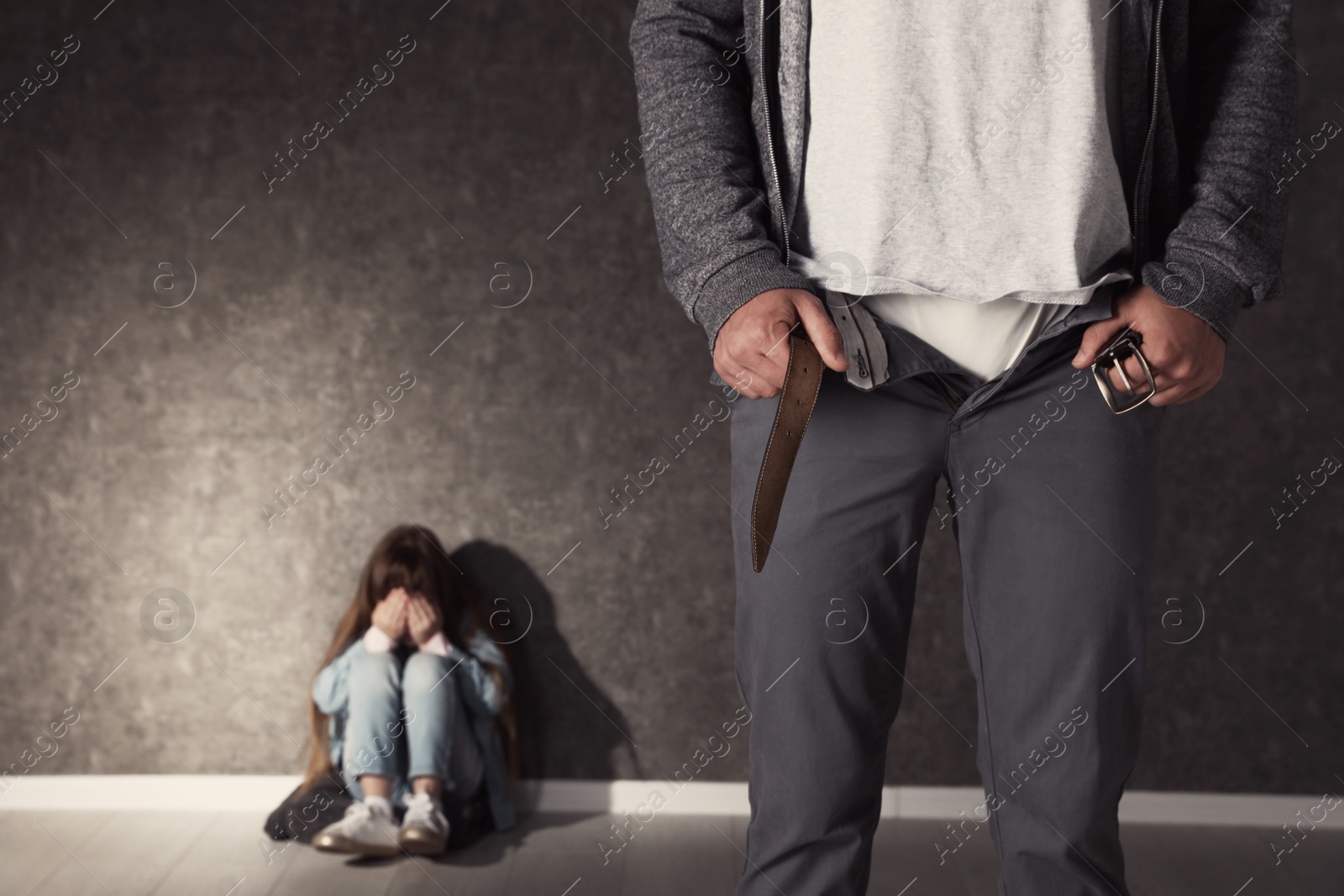 Photo of Man with unzipped pants and scared little girl indoors, space for text. Child in danger