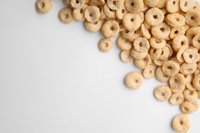 Photo of Tasty cereal rings on white background, flat lay. Space for text