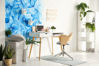 Stylish living room interior with blue flowers painted on wall. Floral pattern