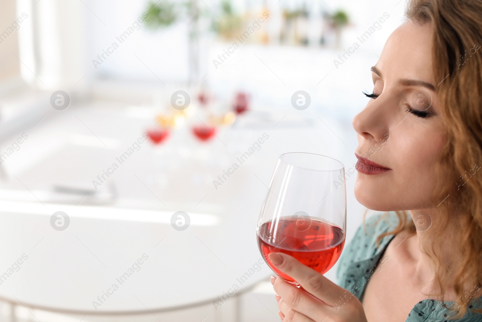 Photo of Woman with glass of delicious wine indoors