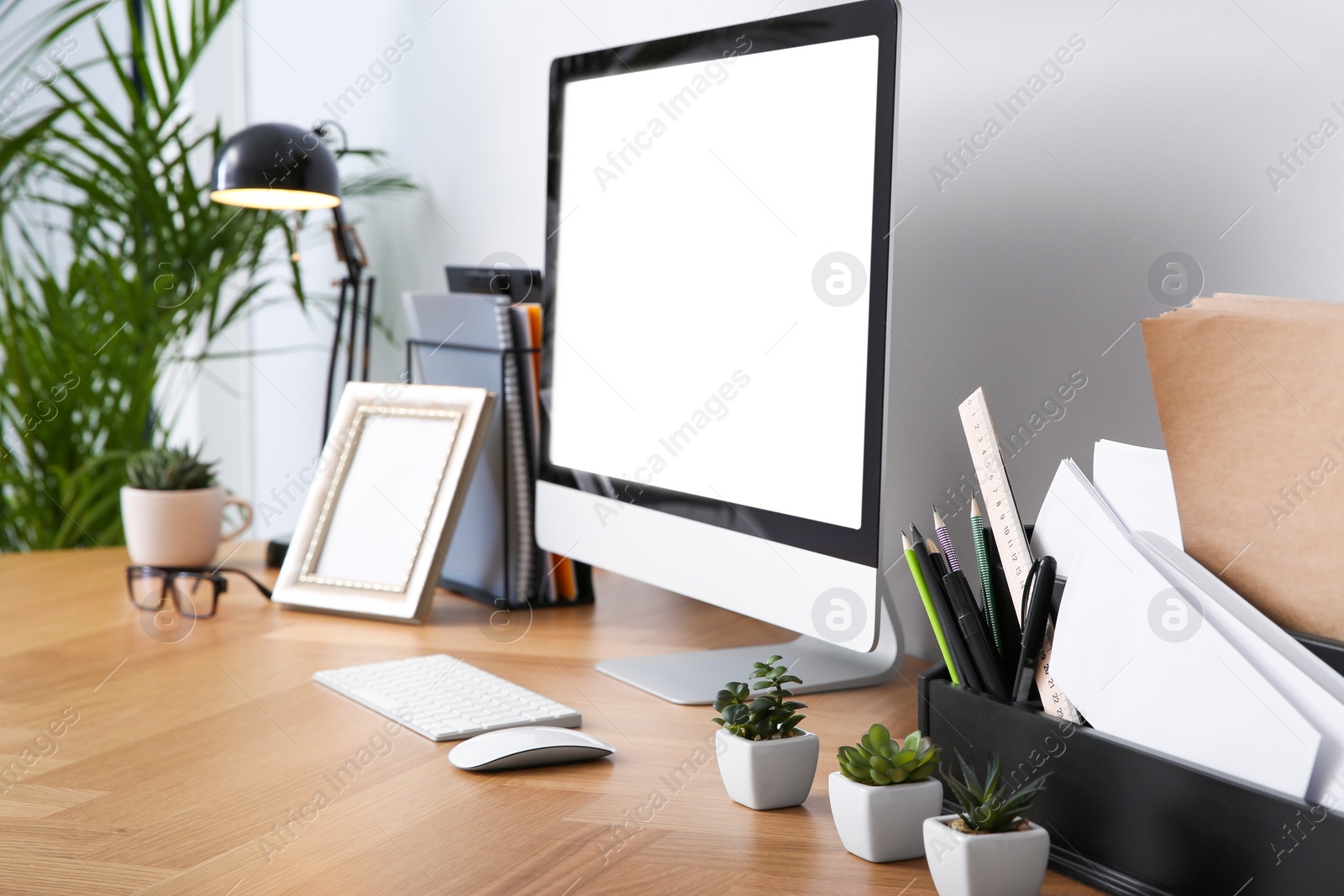 Photo of Modern computer on table in office. Stylish workplace interior