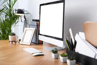 Photo of Modern computer on table in office. Stylish workplace interior