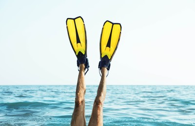 Photo of Man in flippers diving into sea water, closeup