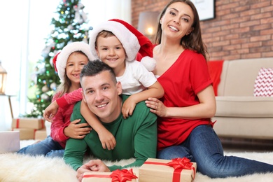 Happy parents and children near Christmas tree at home