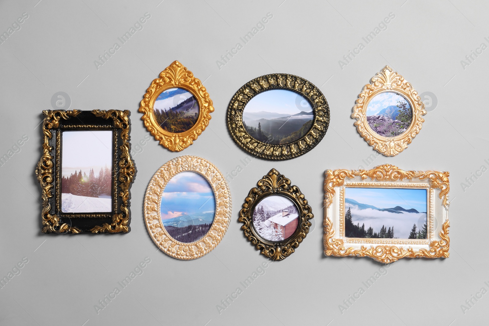 Photo of Vintage frames with beautiful photos of landscapes hanging on light gray wall