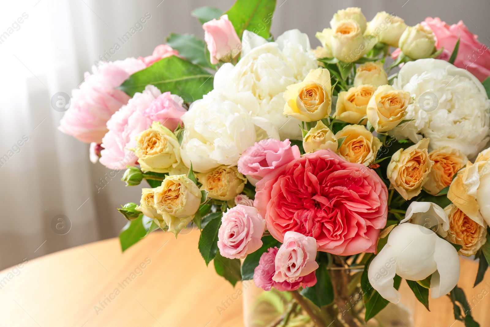 Photo of Beautiful flower bouquet in vase on table near window at home, closeup