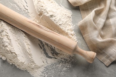 Photo of Pile of flour and rolling pin on grey marble table, top view