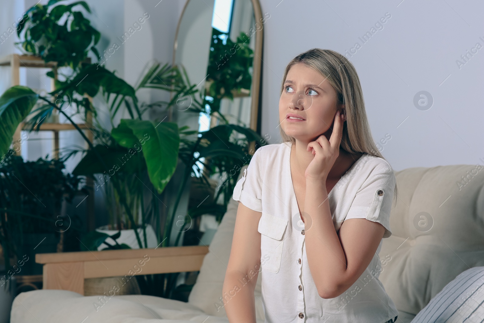 Photo of Young woman suffering from ear pain at home. Space for text